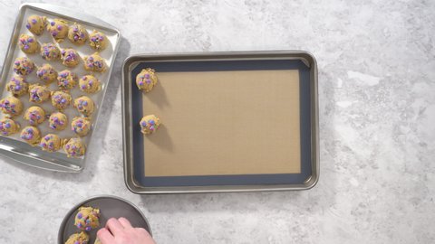 Flat lay. Chilled cookie dough scoops on the baking sheet to bake unicorn chocolate chip cookies.