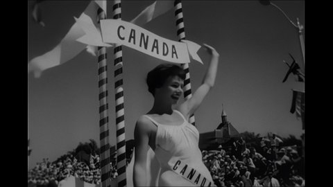 1950s: Women in a swimsuit wave from floats in a parade. Rows of beauty pageant contestants line up. The pageant winner gets a crown and cape. The winner blows a kiss to the crowd.