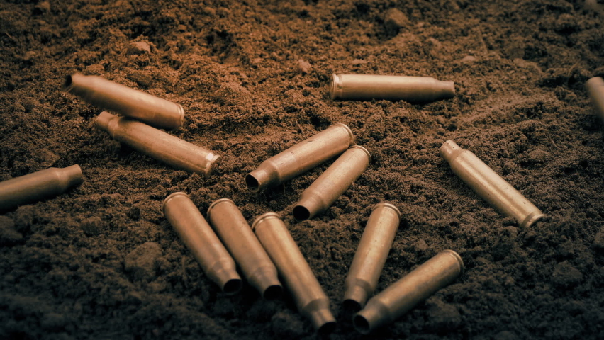 Machine Gun Cartridges Dropping To The Ground In The Dark