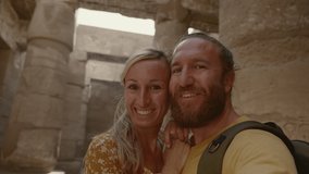 Young couple sightseeing ancient Egyptian temple take selfies 