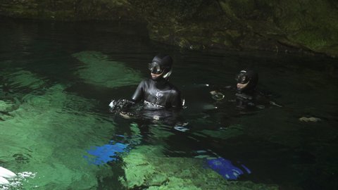 Scuba divers photographers in the cenote lake. 