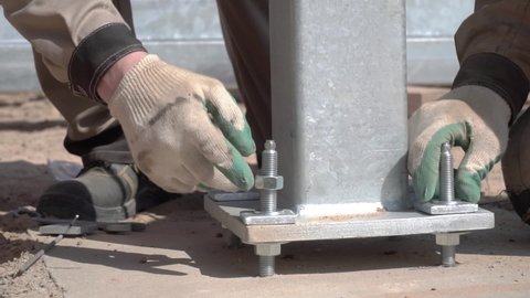 a construction worker tightens a bolt with a metal wrench. close-up back view. Bolted. Cutting metal using modern processing technology.