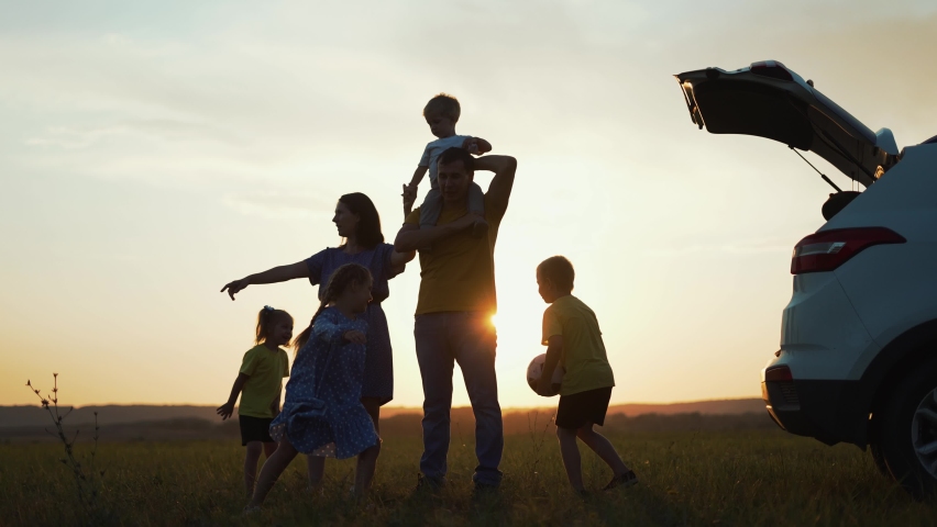 Happy family travel by car. People are having fun on vacation at sunset. Father mother and children picnic in nature. Car travel concept. Children play in park. Happy family concept. Family vacation by car Royalty-Free Stock Footage #1083466726