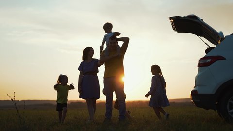 Happy family travel by car. People are having fun on vacation at sunset. Father mother and children picnic in nature. Car travel concept. Children play in park. Happy family concept. Family vacation by car