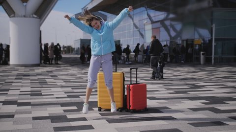 Teen girl with colorful suits dancing at the airport