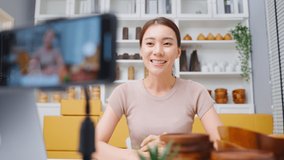 Asian beautiful woman sell vase product online live streaming at home. Young attractive girl use laptop computer shows goods to customer and present detail. Remote buying and purchase shopping concept