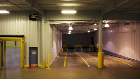 Chicago, November 2021. Cinematic dolly shot in empty loading dock of cargo trucks. Empty garage space ready for loading and shipping delivery. Cargo transportation background business footage