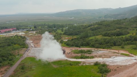 Birds eye of Strokkur geyser, most famous attraction of golden circle, erupting. Top view of powerful eruption of geyser, hot steaming crater in Geysir valley. Touristic destination
