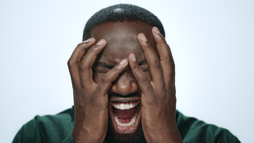 Portrait stressed man screaming on light background. African American male model posing with shocked face expression. Surprised guy shouting in studio. Shocked student yelling camera. Problem stress | Shutterstock HD Video #1083475204