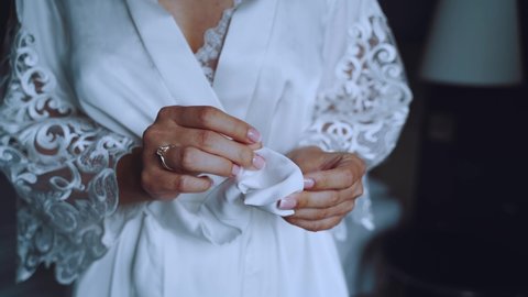 The girl is sorting through the belt of the robe in her hands