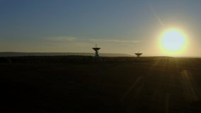 Wide view footage. Aerial drone shot of two telecommunications antenna or Radio telescope satellite dish on sunset