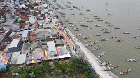 Surabaya, Indonesia (11-24-2021) : Aerial view of the fishing village area with the beach and traditional fishing boats in the Java Sea, north of the city of Surabaya. 