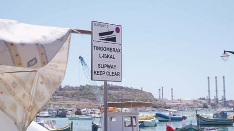 Marsaxlokk , Malta - 11 29 2021: View of the signboard asking the public to keep clear as it is a slipway for boats to get in the water in Marsaxlokk dock, Malta. 