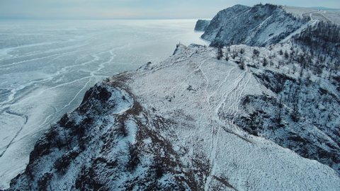 Aerial forward epic winter frozen Baikal lake ice pattern, incredable mountains hills costal nature landscape. Siberia Russia national park. Open space, freedon. Explore North Buryatia. Expedition