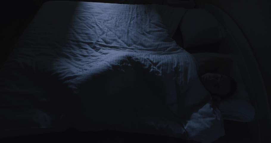 Man tossing and turning in a bed at night, cannot sleep, view from above Royalty-Free Stock Footage #1083492112