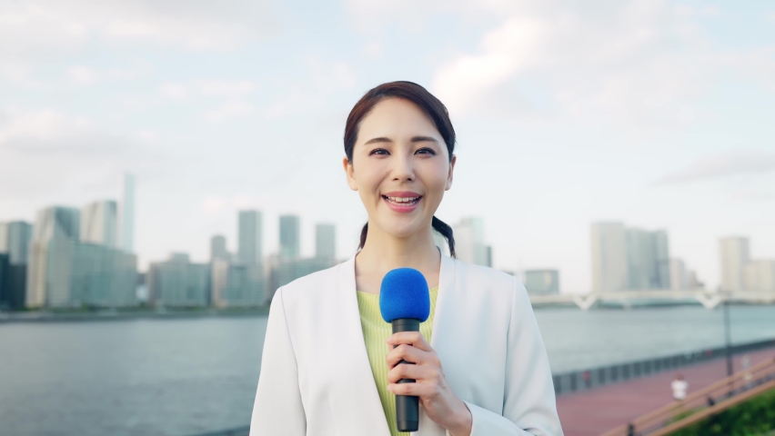 Young asian announcer reporting in front of the city. | Shutterstock HD Video #1083496180