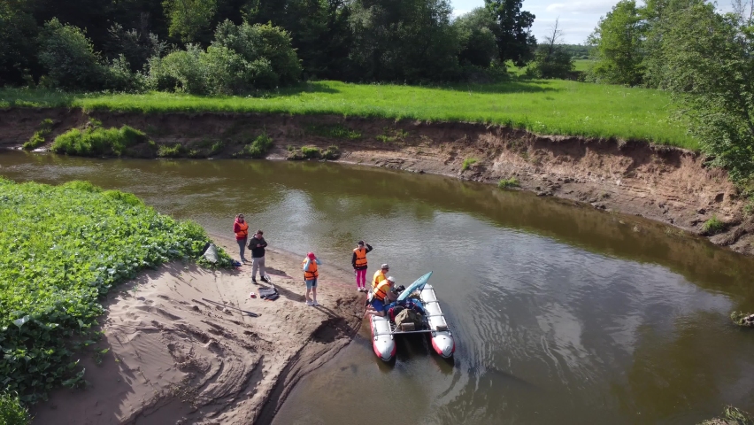 Aerial video from a drone overlooking a wonderful landscape with a river and active young tourists on a catamaran. Vala River, Udmurt Republic, Russia.