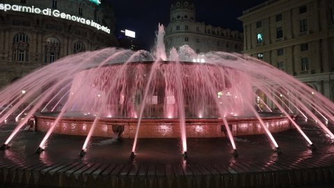 Genoa, Italy - December 4 2021: in the evening, the beautiful fountain, symbol of the city, located in Piazza De Ferrari, illuminated for the Christmas holidays