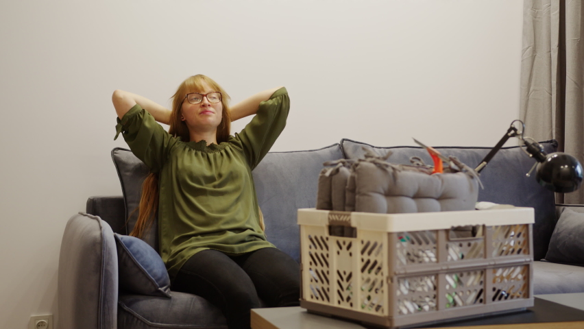 Woman relaxing, sitting on the sofa after housework, cleaning, and the arrangement of the apartment