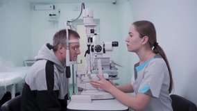 Optometrist examining the eyes of a male patient in a modern ophthalmology clinic. Eye doctor with man patient during an examination in modern clinic. Optometry concept. Eyesight exam in clinic - Powered by Shutterstock - Get 15% off with code: PIKWIZARD15