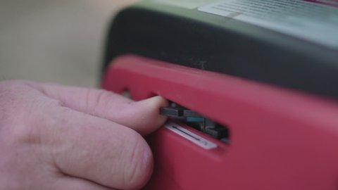 The person turns on the inverter generator by switching the lever. Close-up