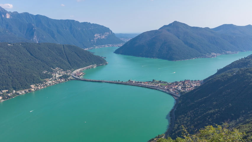 Timelapse, panoramic view of highway going through the lake. Road in the middle of the lake. Melide causeway. View from Monte San Salvatore, Lake Lugano, Canton Ticino, Switzerland