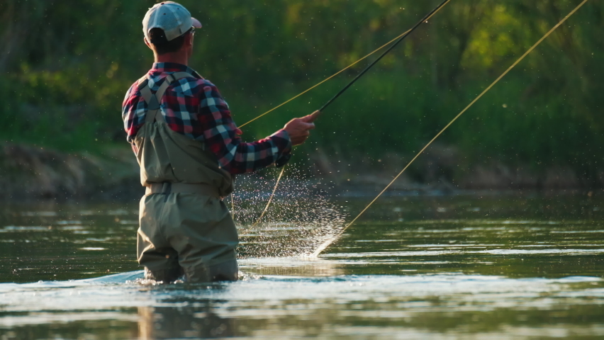 Fly fishing. Man fly fishing on the wild river with lots of insects flying in the air Royalty-Free Stock Footage #1083529033