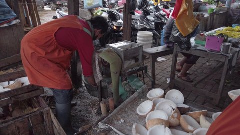 Wonosobo - December 07, 2021 - the process of grating coconuts with machines carried out by sellers in traditional markets