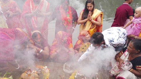 Kolkata , West bengal , India - 12 04 2021: Close-up shot of the people doing rituals for Hindu wedding ceremony near ganga river with fire smoke in Kolkata.