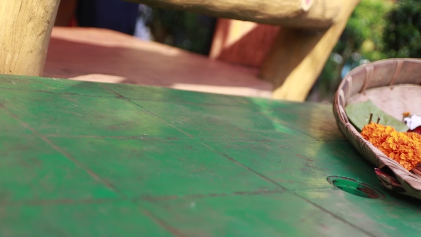 Close-up shot of the ritual items for haldi kept in a kitchen basket on the plastic chair for wedding ceremony.