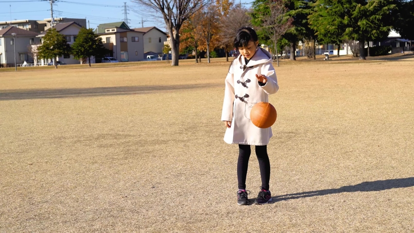 Elementary school girl playing ball in the park