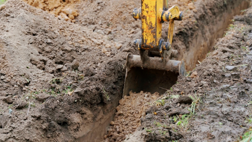 Mini excavator digs a trench to lay pipes. Royalty-Free Stock Footage #1083548278