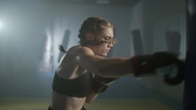 Woman fighter trains his punches, beats a punching bag, training day in the boxing gym, female trains a series of punches fast. - Powered by Shutterstock - Get 15% off with code: PIKWIZARD15