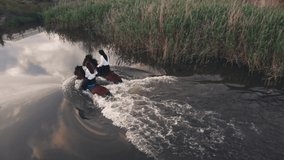 Brunette women friends in white shirts ride chestnut horses wading across calm river with reeds in summer evening backside view - Powered by Shutterstock - Get 15% off with code: PIKWIZARD15