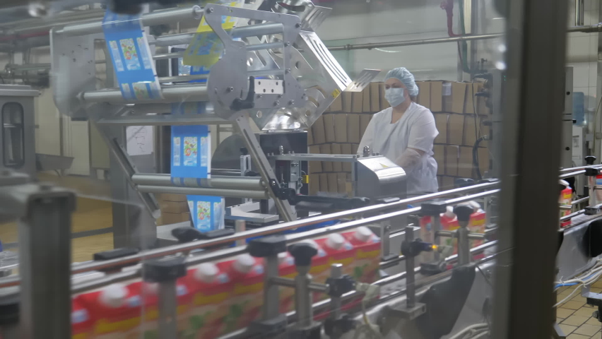 Worker Placing Packaged Dairy Food Brought By Automated Conveyor In Box. Worker Handling Dairy Food Production Conveyor Line. Worker At Industrial Dairy Food Manufacturing Factory Conveyor Line Royalty-Free Stock Footage #1083557125