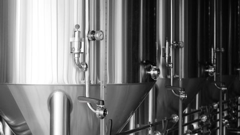 Private microbrewery. Modern beer plant with brewering kettles, tubes and tanks made of a stainless steel