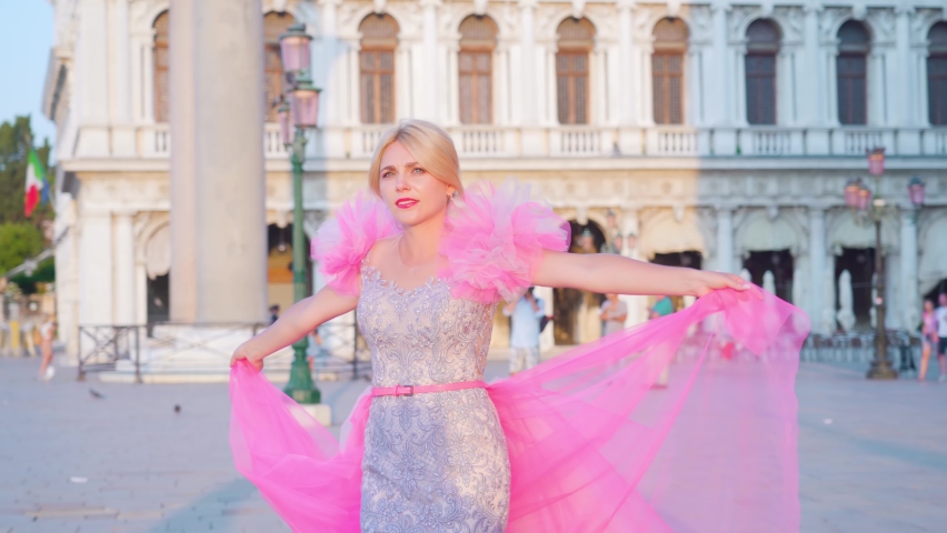 Young blonde girl posing in pink elegant dress