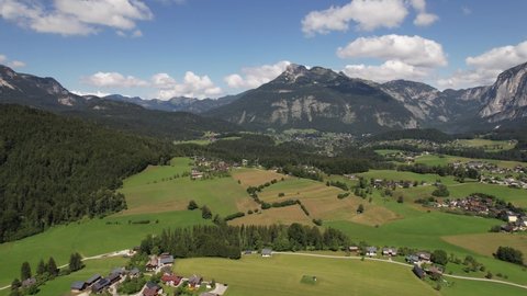 Aerial view of the village, green fields and forest in mountains Alps Austria, travel and nature concept