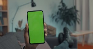 Close up of male hands holding smartphone and pills during video call. Focus on mobile with chroma key screen. Medical consultation for patient during illness.