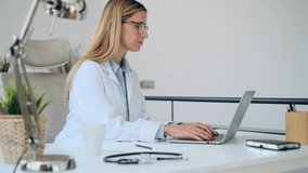 Video of mature concentrated attractive female doctor working with her computer in the consultation. - Powered by Shutterstock - Get 15% off with code: PIKWIZARD15