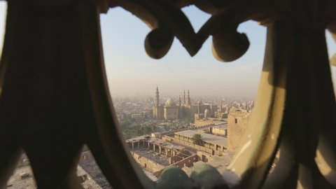 View of Cairo city and Mosque of Sultan Hassan through iron bars of window. View from Citadel of Cairo, gimbal shot