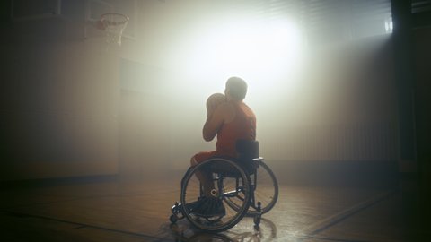 Wheelchair Basketball Player Wearing Red Uniform Shooting Ball Successfully, Scoring a Perfect Goal. Determination, Training, Inspiration of Person with Disability. Dolly Slow Motion with Warm Colors