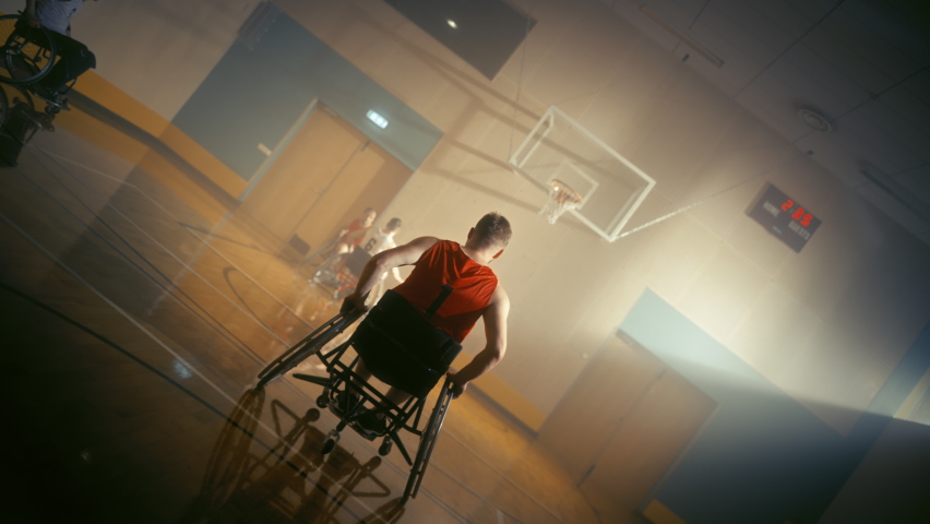 Wheelchair Basketball Game: Professional Players Competing, Dribbling Ball, Passing, Shooting and Scoring a Goal. Celebration of People with Disability. Stylish Cinematic Slow Motion Dutch Angle Shot Royalty-Free Stock Footage #1083576583