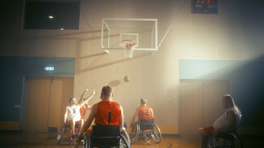 Wheelchair Basketball Game: Professional Players Competing, Dribbling Ball, Passing, Shooting and Scoring a Goal. Celebration of People with Disability. Stylish Cinematic Slow Motion Dutch Angle Shot Royalty-Free Stock Footage #1083576583