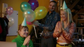 Group Of Young Caucasian Office Workers Surprising Their Pretty Co-Worker With an Office Birthday Party, Bringing Her a Fancy Cake and a Party Hat. Birthday Girl is Surprised and Beyond Happy, Smiling - Powered by Shutterstock - Get 15% off with code: PIKWIZARD15