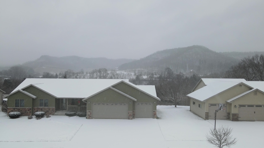 Snow over rural landscape valley in Wisconsin. Dips and curves of unique land. Two creeks and farmland. Homes on edge of beautiful scene. 