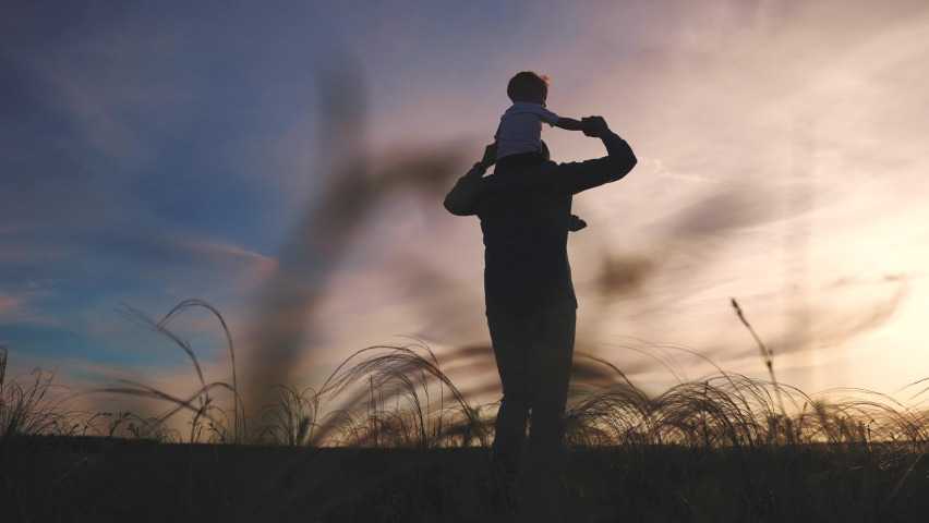 father and son in the park. father day silhouette happy family kid dream concept. father carries a piggyback son on his back. dad playing with his son in nature in the park silhouette fun at sunset Royalty-Free Stock Footage #1083585001