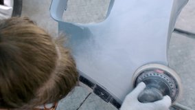 Woman worker in goggles and overalls cleans surface of car bumper with sanding machine in auto service garage before painting closeup - Powered by Shutterstock - Get 15% off with code: PIKWIZARD15