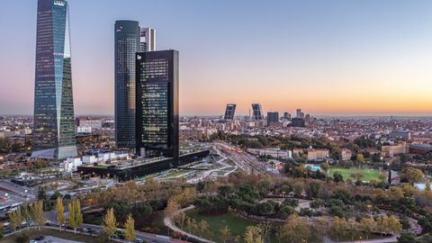 Backwards reveal of modern high rise buildings in business district. Aerial hyperlapse footage of at dusk. Madrid, Spain