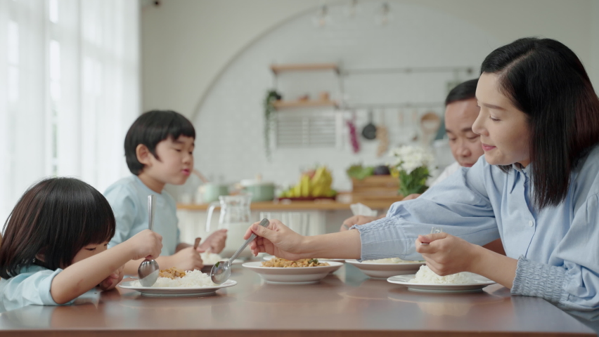 Asian family eating breakfast at the dining table inside the kitchen, family relationships | Shutterstock HD Video #1083603937